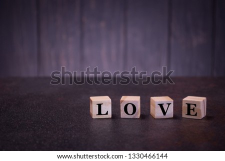 Word love on wooden cubes, on a dark background, light wooden cubes signs, symbols signs, business office, site content