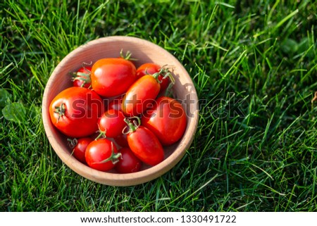 An images of red tomatoes on a wooden plate