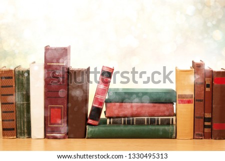 Collection of old books on wooden table on library background