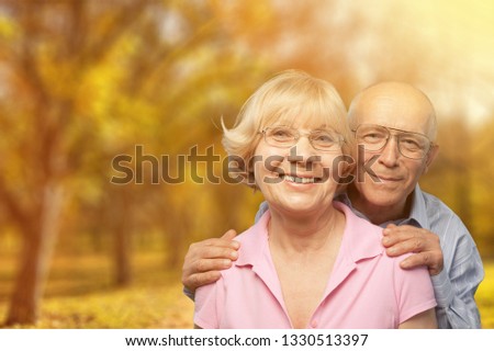 Close-up portrait of an elderly couple hugging in park
