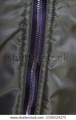 Close up of olive green jacket zipper , winter fashion outfit. Jacket isolated on white background.