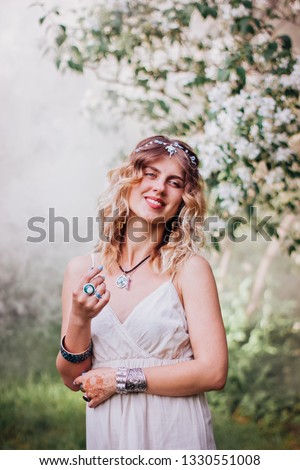 Bohemian hippie girl in white dress.
Woman with lot of boho style jewelry, blue rings,silver bracelets and henna tattoo.  Coachella fashion style look, outfit.