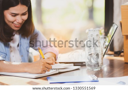 Asia woman using laptop computer,smartphone working in office ,home with happy.
