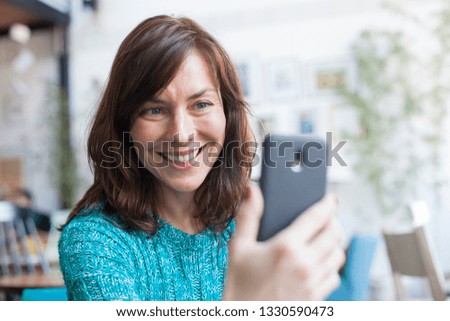 portrait of a woman taking selfie with smartphone