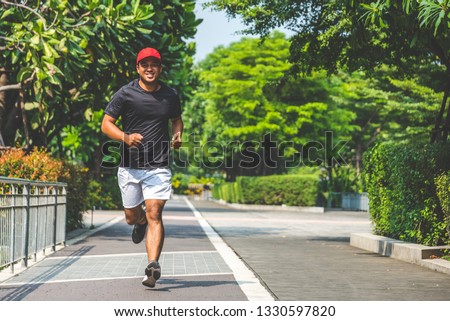 Young asian man running in the urban city with copy space. Fitness, workout, sport, lifestyle concept. Royalty-Free Stock Photo #1330597820