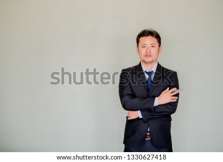 A handsome young Asian businessmanin office suit posing