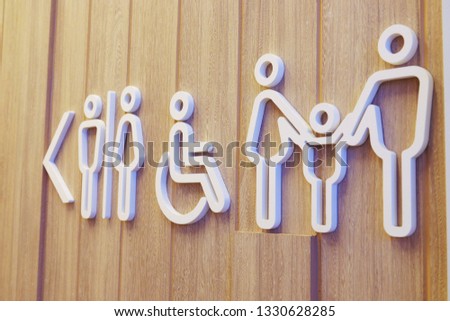 Public restroom signs for family in public area. on a wooden wall background