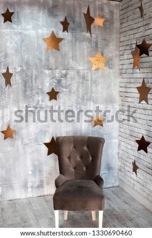 An armchair over which the yellow stars hang. Studio decor.