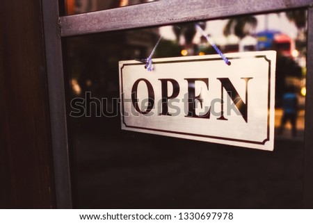 Open sign hanging front of cafe with colorful bokeh light abstract background. Business service and food concept. Vintage tone filter effect color style.