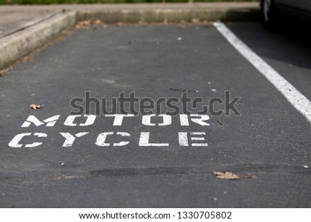 Motorcycle parking spot in an asphalt parking lot
