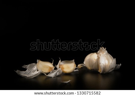 close up peeled garlic with small pieces on a black background with a free copy space.Concept for healthy food
