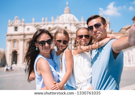 Happy young family taking selfie at St. Peter's Basilica church in Vatican city, Rome. Happy family on european vacation in Italy.