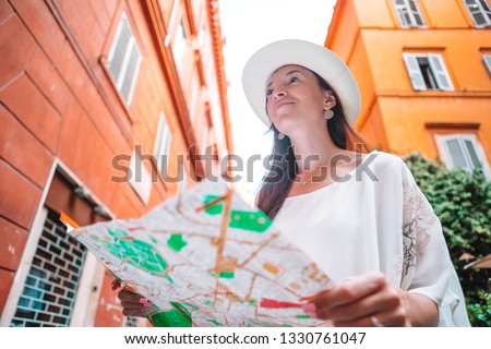Tourist young woman with a city map on italian old street in Europe. Travel tourist woman with map in Rome outdoors during holidays in Italy.