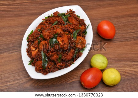 Andhra chicken fry or chicken 65 hot and spicy dish garnished with curry leaves Kerala. a popular authentic roasted dish deep fried in coconut oil  South India. fried in a coating of Indian spices.