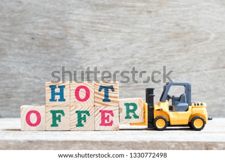 Toy forklift hold letter block R to complete word hot offer on wood background