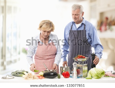 Senior man and woman cooking together in the kitchen.