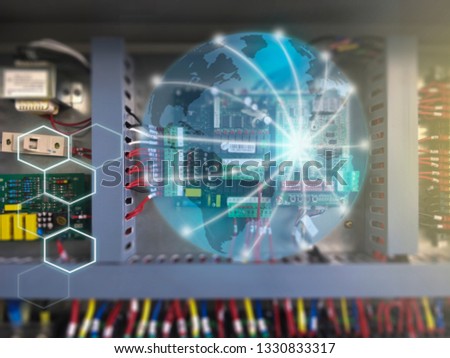 Global network concept and world globe overlay blue light with electrical control cabinet blurred background.