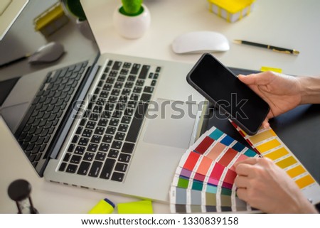 graphic designer working with computer and color swatch. creative woman using digital tablet at modern office. Architect using work tools and sample colour catalog.
