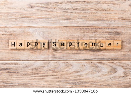 Happy september word written on wood block. Happy september text on table, concept.