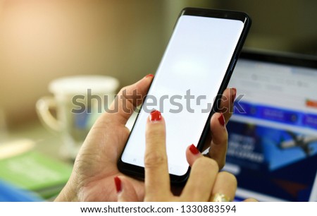 Woman holding smart phone with bank moblie can be add your texts or others. at office