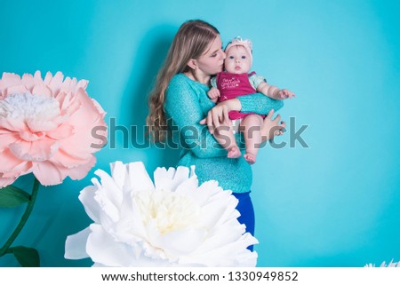 Happy loving family. mother and child girl playing, kissing and hugging on blue background