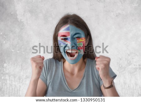 Young woman with painted flag of Fiji and open mouth looking energetic with fists up