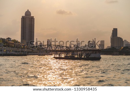 Landscape picture view with ferry crossing on the Chao Phraya river at the morning with buiding background.