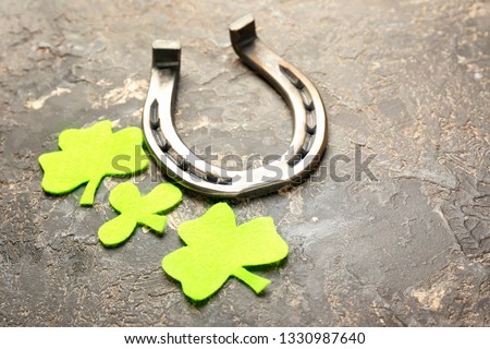 Composition with horseshoe and clover for St. Patrick's Day on grey background
