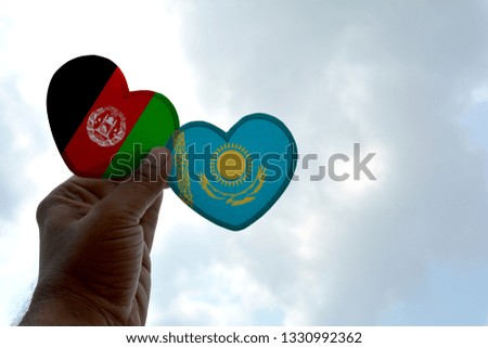Hand holds a heart Shape Afghanistan and Kazakhstan flag, love between two countries