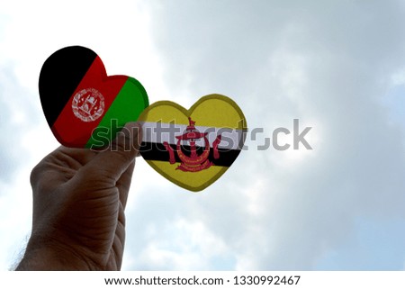 Hand holds a heart Shape Afghanistan and Brunei flag, love between two countries