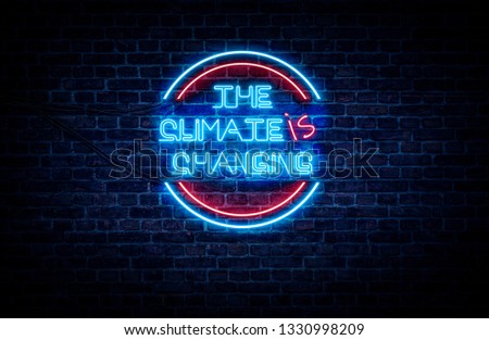 A blue and red neon sign on a brick wall that reads: THE CLIMATE is CHANGING .