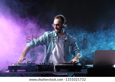 Male DJ playing music in club Royalty-Free Stock Photo #1331021732