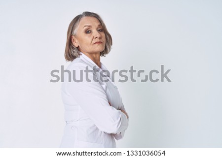 Pretty woman in white shirt hands in front of herself on gray background