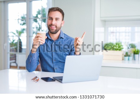 Handsome man working using computer laptop and drinking a cup of coffee very happy pointing with hand and finger to the side
