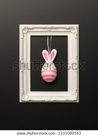 An image of a happy easter decoration with a bunny egg in a frame