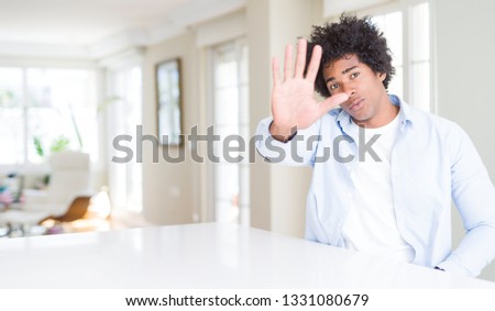 African American man at home doing stop sing with palm of the hand. Warning expression with negative and serious gesture on the face.
