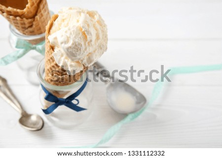 Waffle cone with delicious ice cream in jar on white table