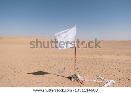 A white flag waving in the desert.