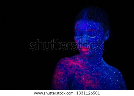 Picture of a pink jellyfish on the shoulder and face of the beautiful woman. ultraviolet body art. The girl hung her head to the shoulder