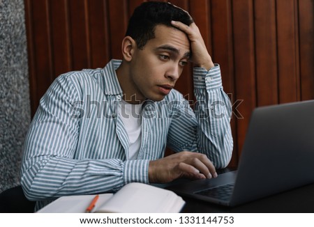 Frustrated stressed business man using laptop computer, he missed deadline and solving problems at workplace. Portrait of tired programmer developer working project online, brainstorming in office.   