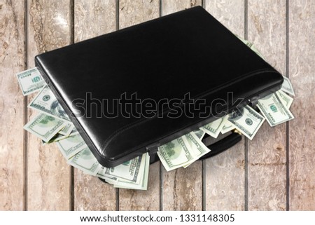 Black suitcase full of banknotes on backgrouund