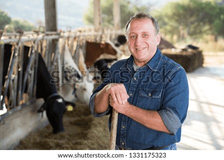 Portrait of confident senior man owner of dairy farm