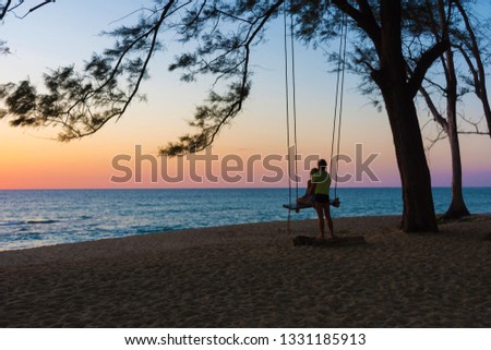 Couple sitting on the swing watching the sunset