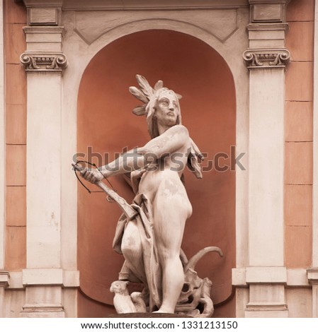 American Indian woman, with a crossbow in hands. Old stone statue