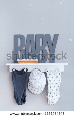 Shelves with hanger in modern baby room. Text baby.