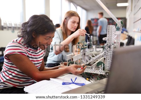 Two Female College Students Building Machine In Science Robotics Or Engineering Class Royalty-Free Stock Photo #1331249339
