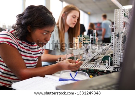 Two Female College Students Building Machine In Science Robotics Or Engineering Class Royalty-Free Stock Photo #1331249348