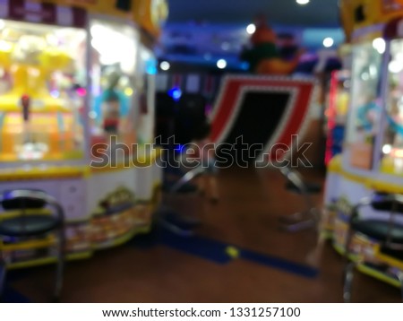 blurred arcade machine game for children game play  in department store. Playground with colorful neon lights and bokeh light. Colorful absract background.