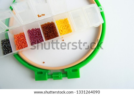 Flat lay Accessories for needlework and embroidery, hoops and beads on white background