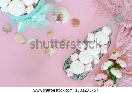 Meringues and marshmallows on handcrafted transparent serving plate on pastel pink background. Dessert concept. Top view. Copy space